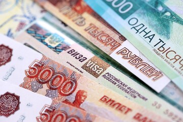 Fragment of Russian Federation visa in passport page and russian rubles money bills close up....