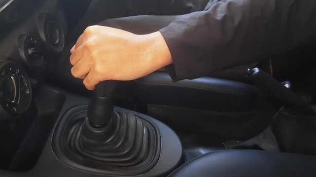 man hand switching a manual gear shift in the car