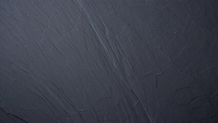 Dark grey natural slate surface showing rough stone texture with subtle lines and cracks, providing an organic background for design and abstract concepts