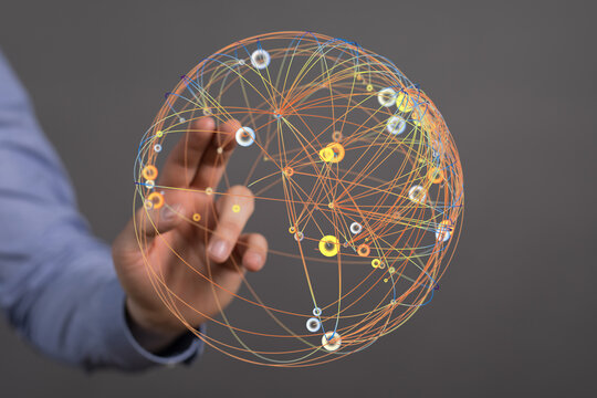 Abstract conceptual image of a hand interacting with a glowing network sphere representing global connections, data transfer and comm