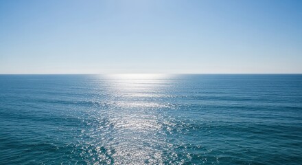 Serene Blue Ocean and Clear Sky with Sparkling Sun Reflection at Horizon