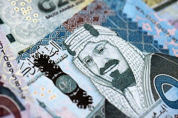 Saudi Arabia riyal money bills banknotes lies in big pile on table close up. Concept of finances...