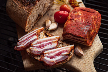 Freshly sliced bread topped with smoked bacon and juicy tomatoes creates a perfect treat outside