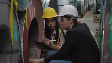 group of diversity Caucasian male manager and an Asian female engineer working with tablet inspect large metal coils in warehouse digital inventory check quality control industrial management teamwork - Powered by Adobe