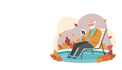Senior man enjoys fall leisure relaxing in a chair and using his smartphone surrounded by pumpkins