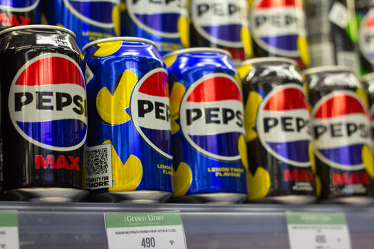 Yerevan, Armenia - November 8, 2025: Row of metal black and blue cans with Pepsi logo Max and lemon flavor lemonade on shelf of shop, store. Concept of soda water, cold soft drink, fast food, beverage