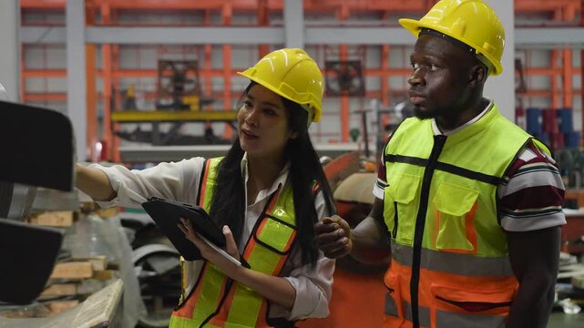 diverse team Asian female engineer and  african american discusses plans on tablet during a factory inspection.multicultural teamwork, female leadership, and digital technology in industrial safety