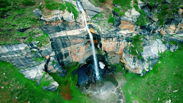4K Aerial shot Para Lam waterfall in summer mountain valley at Suralbhatori, Pangi Valley, India. Powerful waterfall with crystal clear water from a melting glacier, flowing down. Beautiful landscapes