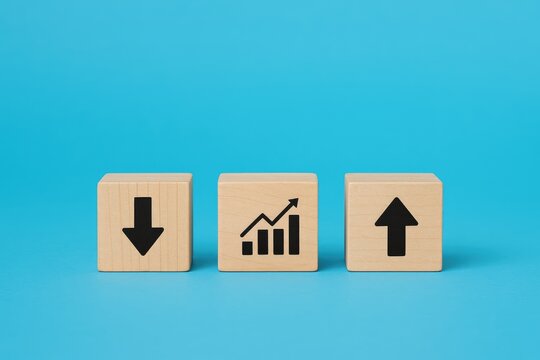 Wooden cubes with up and down arrows and graph icons on blue background, financial metrics