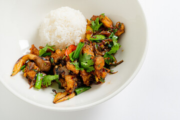 Brightly colored stir-fried chicken mixed with herbs and served with a mound of rice