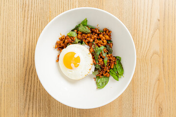 A hearty bowl with spicy chicken, fresh spinach, and a golden fried egg for a flavorful mix