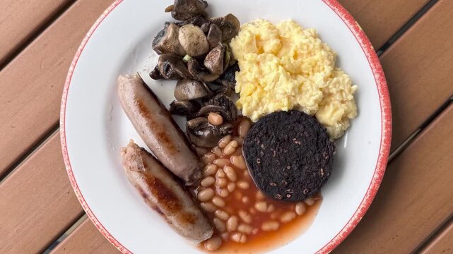 British Breakfast of Scrambled Eggs, Baked Beans, Mushrooms , Blood Pudding and Sausages