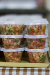 Vertical Photo Brazilian sauce in Plastic Containers – traditional Fresh-Chopped Vegetable Salsa with Vibrant Colors and a Practical Presentation for Meal Prep