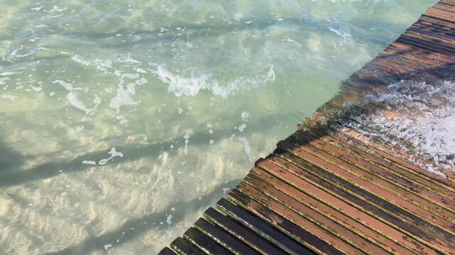 Water flowing into the wooden deck at paradisiacal lagoon.