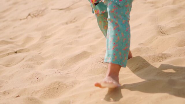 Closeup shot of feet of Indian woman barefoot walking on desert sand at Jaisalmer, Rajasthan, India. Tourist exploring Sam sand dunes at Thar desert. Travel and holidays concept.