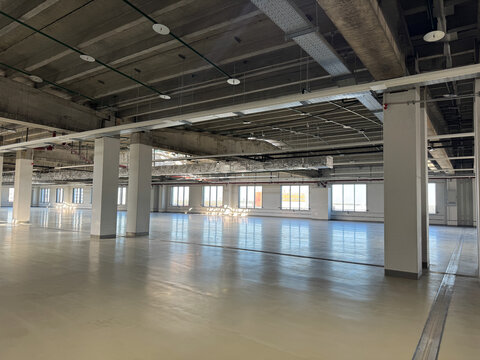 Industrial unit. Spacious, modern industrial warehouse interior with concrete floor and bright lighting, empty space and potential for business.