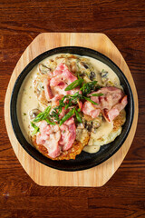 Crispy bacon topped with a rich mushroom sauce, served on a warm skillet, inviting you to taste