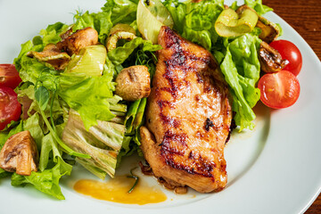 Savory grilled chicken rests atop crisp lettuce with colorful tomatoes and mushrooms surrounding it