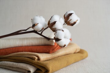 Stack of Linen Fabrics with Cotton Sprigs - Textured Background