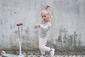 Little 4 Year Old Girl Walking with a Scooter