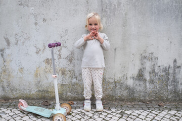 Little 4 Year Old Girl Walking with a Scooter