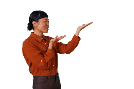 Asian woman presenting and gesturing, showing empty space for product or information, smiling, orange shirt - Powered by Adobe