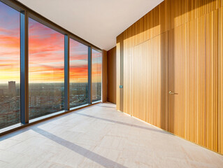 Modern interior with large windows overlooking city at sunset