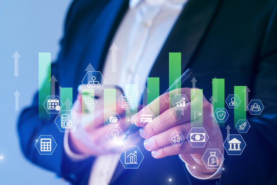 Business professional analyzing marketing trends with digital graphs and icons in a modern office setting