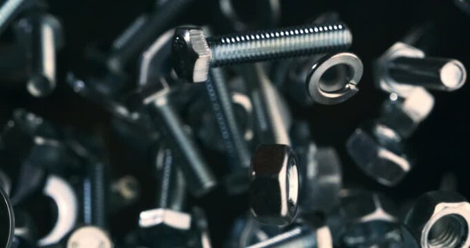 Slow Motion Close Up Shot Of Stainless Steel Nuts And Bolts Suspended In Air, Spinning, Colliding And Reflecting Light With Industrial Precision And Mechanical Energy At 1000 Fps.