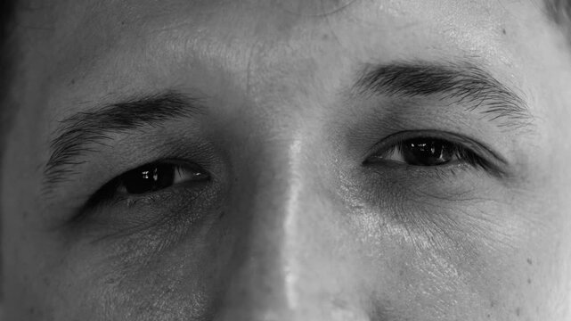 Macro close up man’s eyes in black and white, calm introspective expression conveying thoughtfulness, realism, and emotional depth