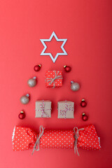Gift boxes and christmas baubles arranged on red background. Creative holiday composition symbolizing festive mood and joyful celebration. Flat lay, vertical photo