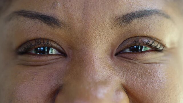 Macro close up of African American woman smiling with her eyes, intimate portrait showing joy, warmth, and the authenticity of genuine emotional expression