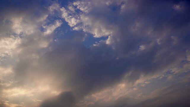Soft pastel evening sky with textured clouds and gentle warm light spreading across the horizon.
