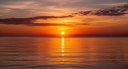 Fototapeta premium Vibrant Orange Sunset Over Calm Ocean with Dramatic Sky Reflection