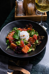 Fresh Salad with Poached Egg and Smoked Salmon in a Gourmet Setting