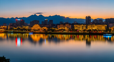 Naklejka premium City skyline reflected in water at dusk with mountain backdrop