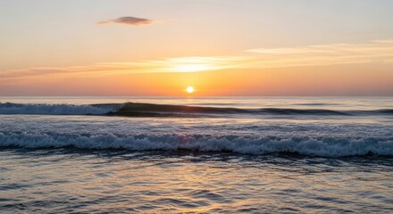 Obraz premium Golden Ocean Sunset with Gently Rolling Waves and Tranquil Sky