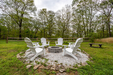 White Adirondack Chairs Around Stone Fire Pit