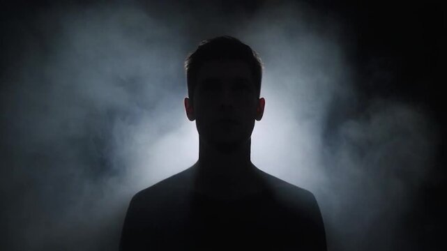 Male silhouette against bright fog and darkness