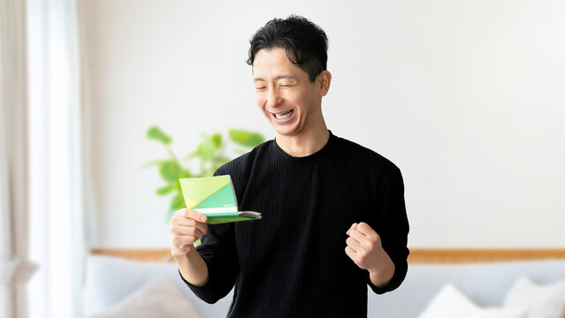 通帳を見て喜ぶ男性