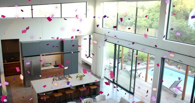 Offscreen burst sending confetti drifting and rotating across two-story kitchen, celebrating party