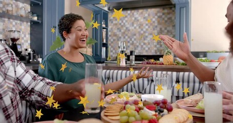 Woman in green laughing and raising arms as stars falling, dining group sharing drinks toasting - Powered by Adobe