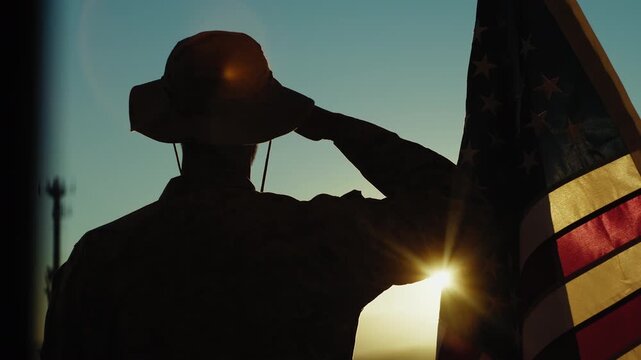 Silhouette of an American soldier in Front of a Flag Saluting During Memorial Day