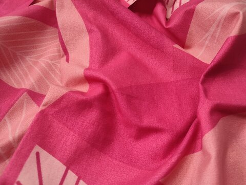 The pattern, texture, and background of the fabric are gray with red geometric patterns.