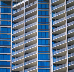 Closeup of a White Building Wall with Blue Opaque Windows.