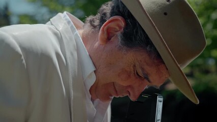 Capturing moments with an analog camera in nature by a man wearing a fedora