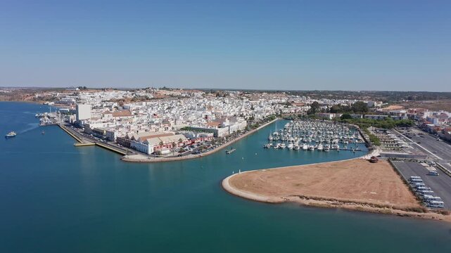 Aerial view drone shot of Ayamonte aerial view marina sandbar with boats bright turquoise water busy yacht berths promenade and parking sailing activity at river mouth clear sky summer