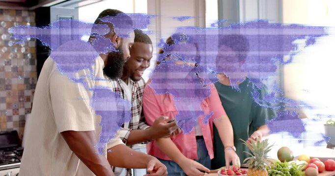 Four adults preparing fruit at island, man scrolling phone sharing recipe while purple map clearing