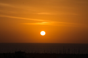 Obraz premium Dramatic orange and yellow sunset over the sea horizon. Scenic landscape symbolizing hope, travel, and tranquility.