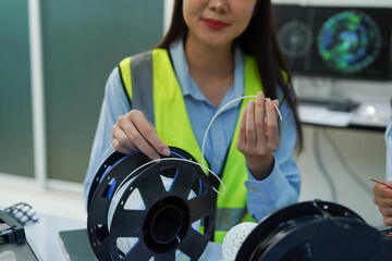 Technicians work with a 3D printer to print a clear white plastic model using cutting-edge technology, focusing on specific points, in a lab.